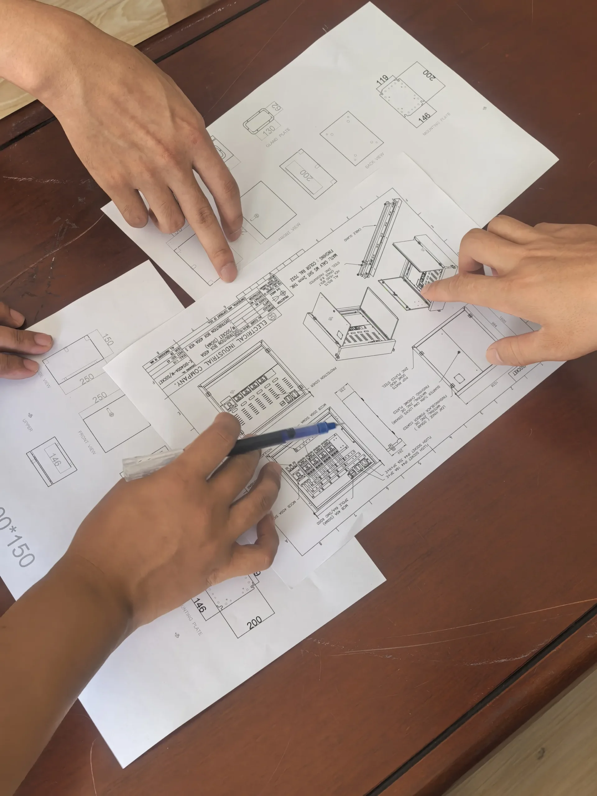 Engineers reviewing CAD drawings for a custom electrical enclosure
