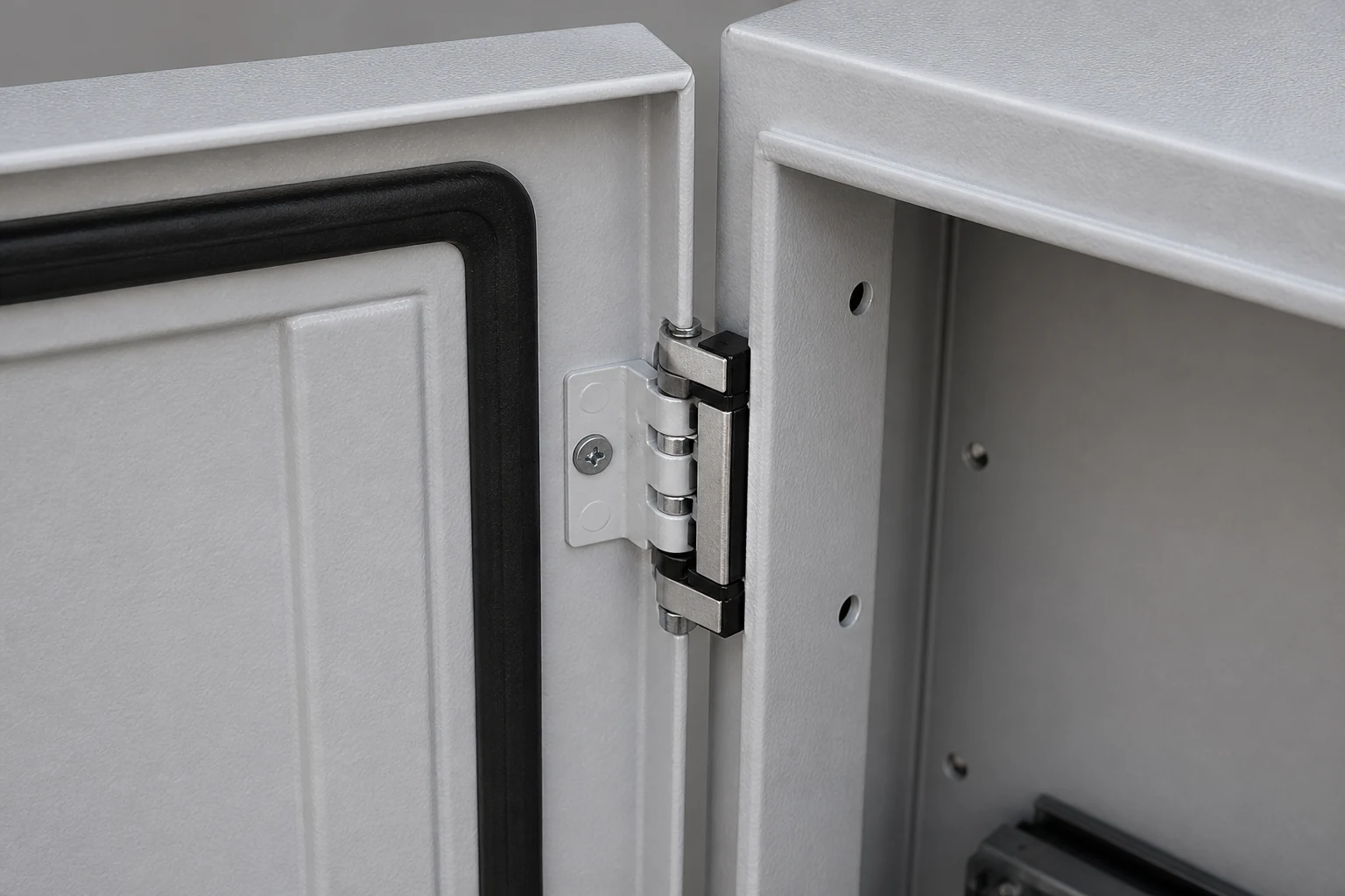 Close-up of an electrical enclosure hinge, door gap, and gasket path
