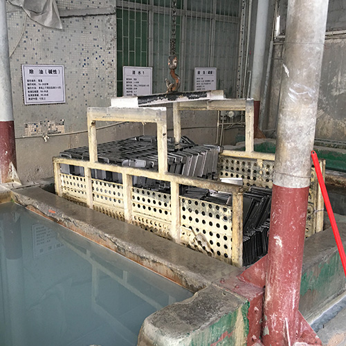Metal electrical enclosure parts undergoing acid pickling pretreatment