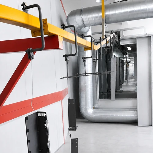 Sheet metal enclosure components moving through an industrial powder coating line